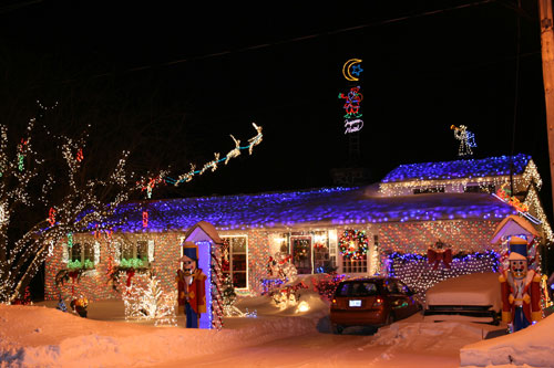 a home decorated in christmas lights after a fresh dusting of snow