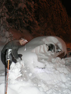 shovelling off car in the dark during early morning