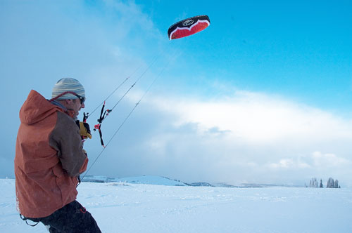 snowkiter in foreground and kite up in sky