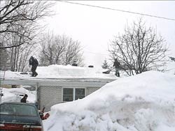 shovelling snow off a roof during the middle of winter